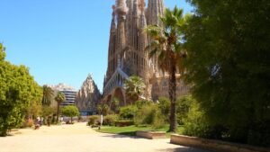 Sagrada Família in Barcelona on a sunny morning, palm trees in the foreground